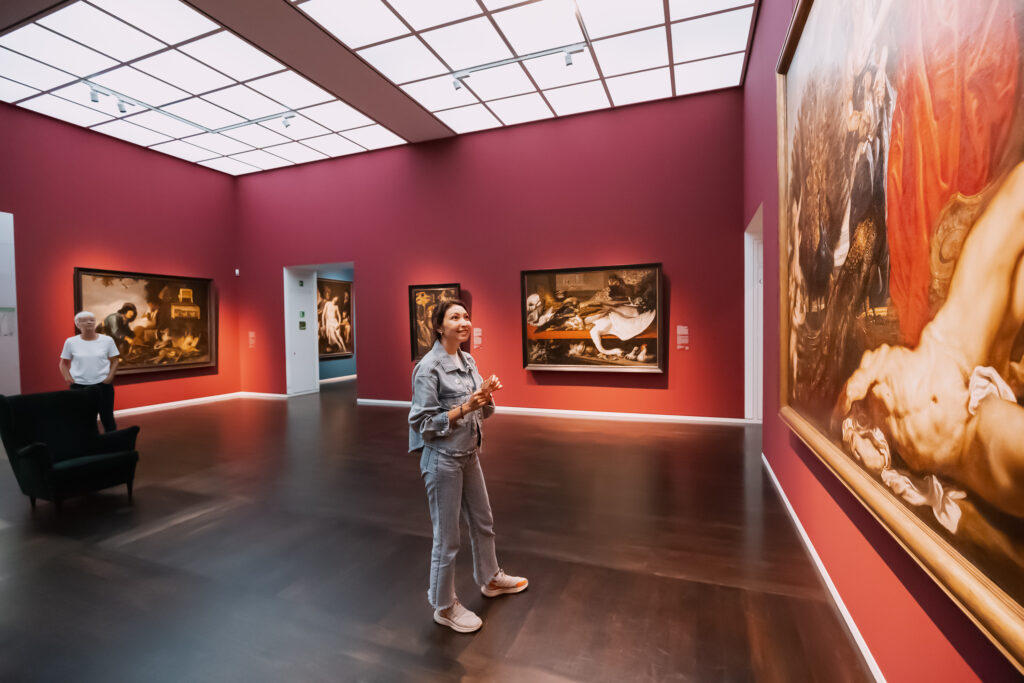 31 July 2022, Koln, Germany: Female visitor looking at classical masterpiece at art exhibition in Wallraf Richartz museum