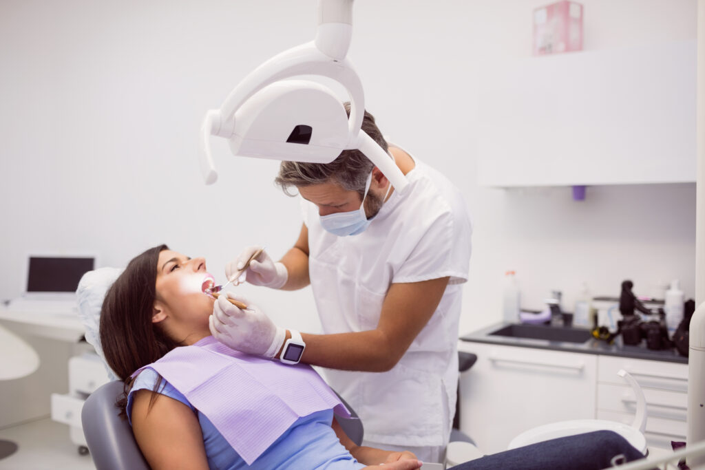 Dentist examining female patient teeth in clinic