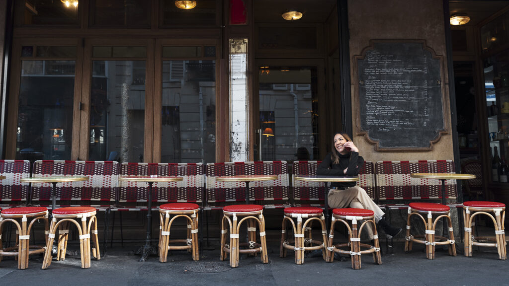 full-shot-smiley-woman-sitting-bistro