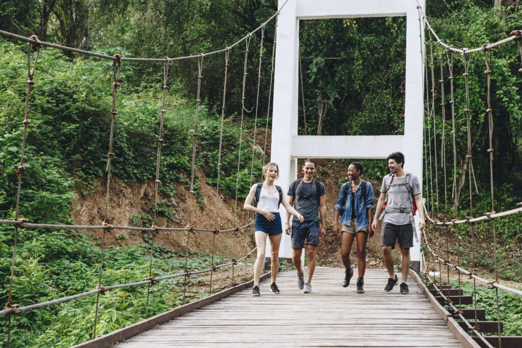 group-friends-walking-bridge-tropical-countryside-adventure-journey-concept