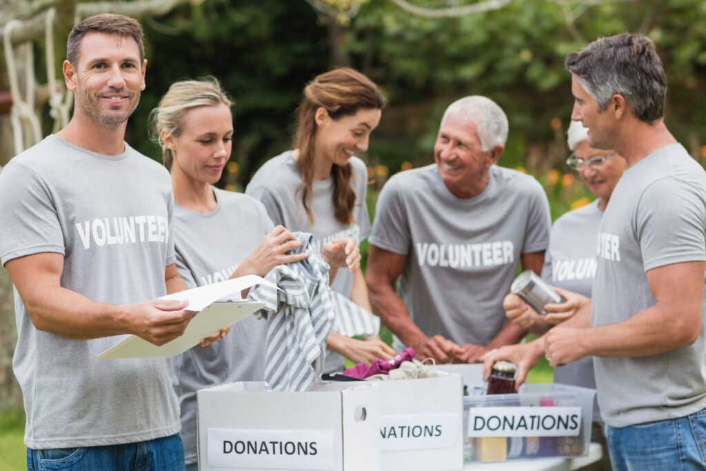 Happy volunteer looking at donation box on a sunny day