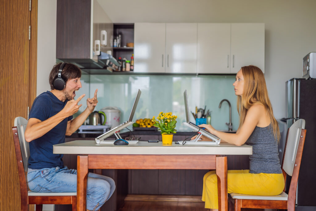Man and woman working at home in the kitchen during quarantine COVID 19