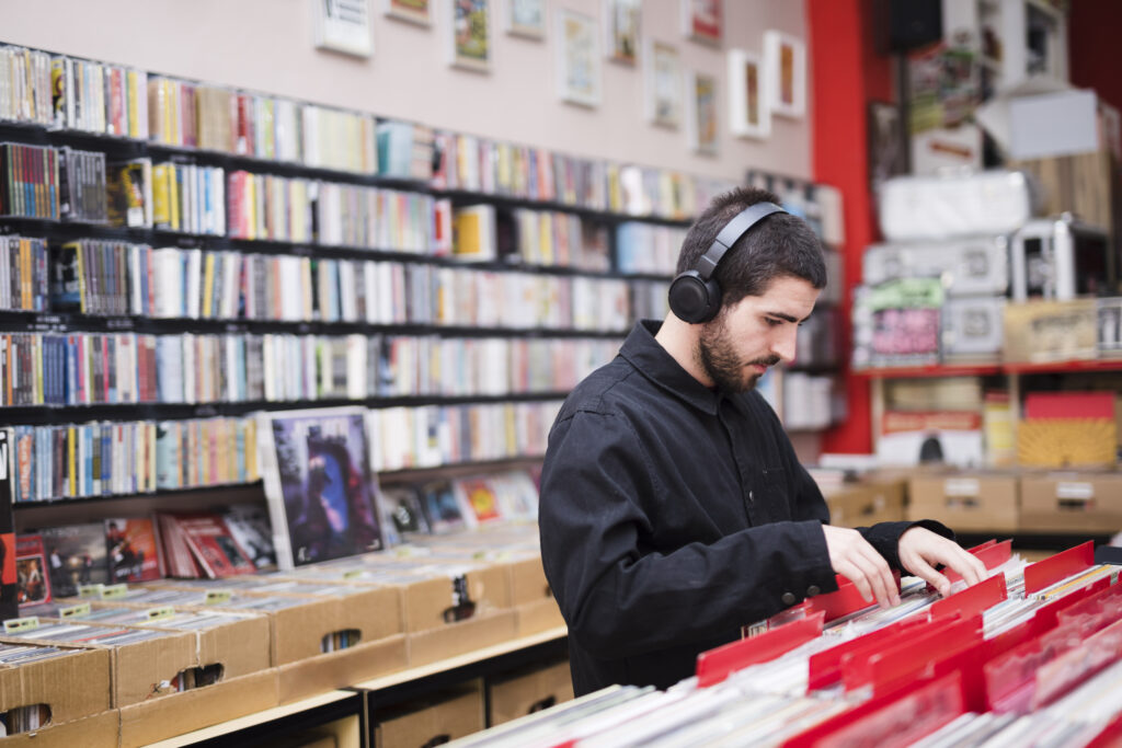 medium-shot-side-view-young-man-looking-vinyls-store