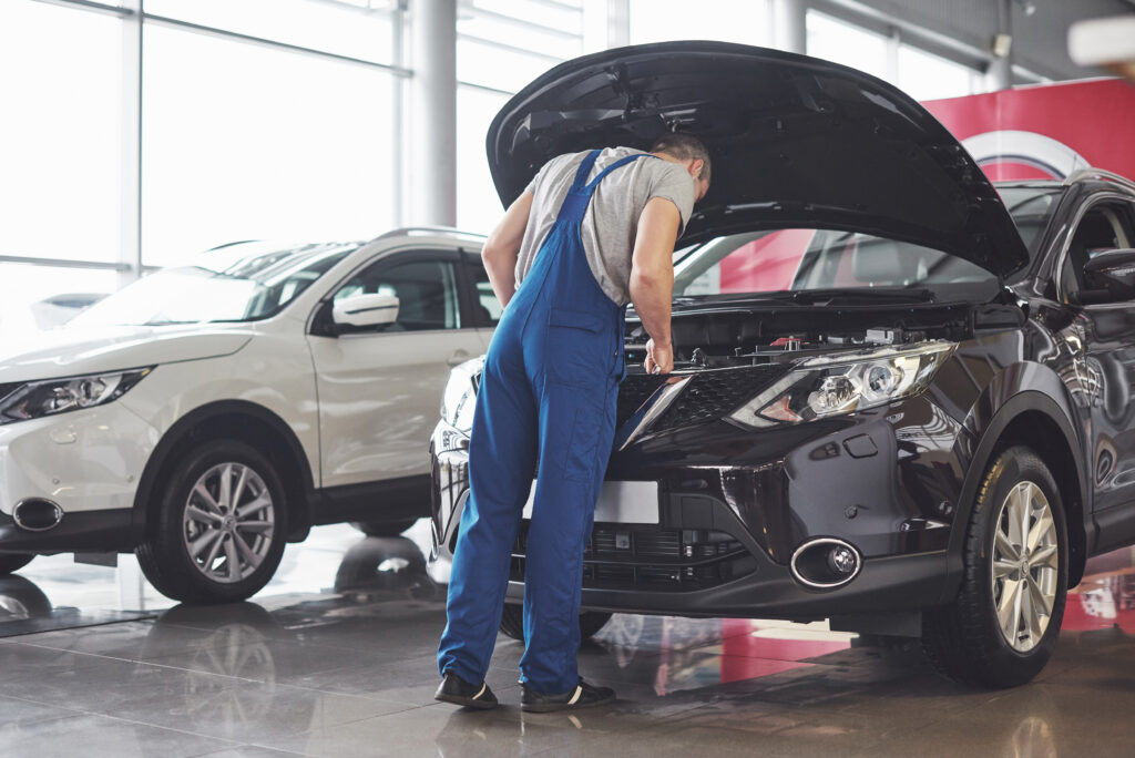 Picture showing muscular car service worker repairing vehicle