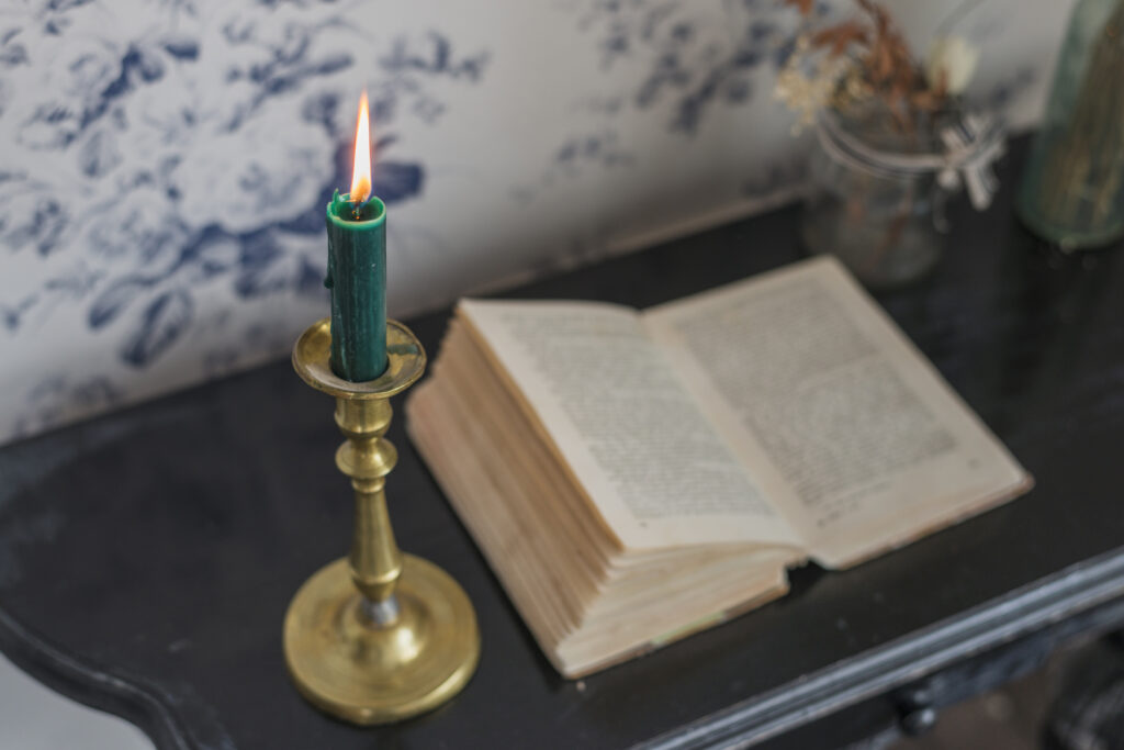 overhead-view-open-book-lighted-candle-desk