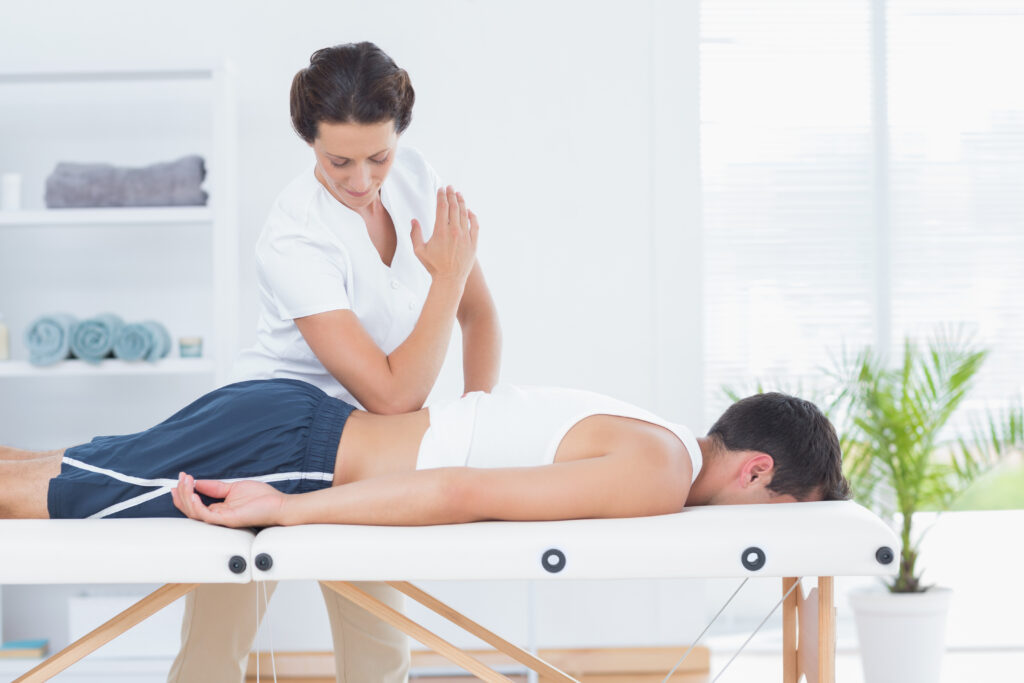 Physiotherapist doing back massage in medical office