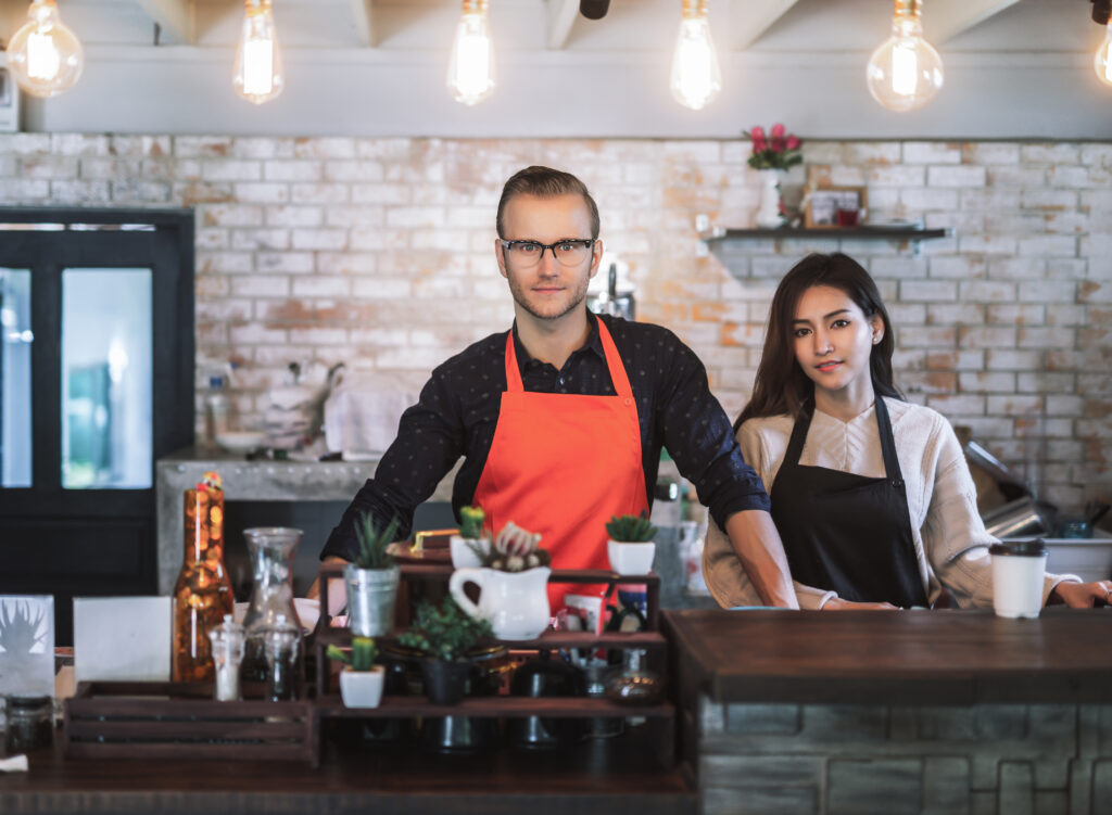 Portrait business owner couple wear apron