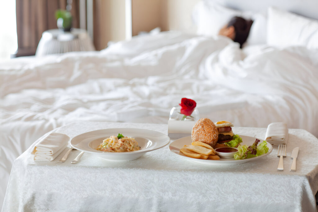 room-service-food-meal-delivery-luxury-hotel-room-with-hamburger-spaghetti-bed-sleeping