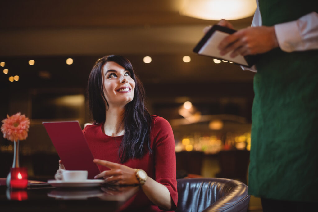 Waiter taking order from woman in a restaurant